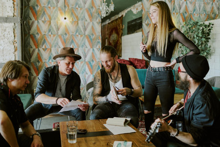 Group of gen X and gen Y musicians spending time in abandoned house working together on rock music...