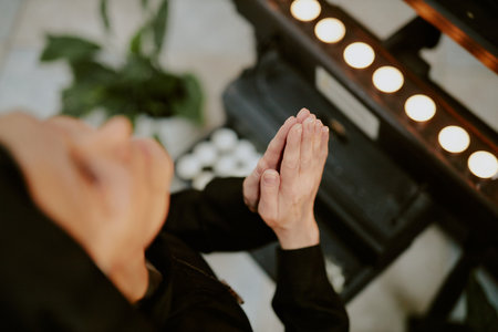 High angle view closeup of unrecognizable mature Caucasian nun praying to God in front of altarの写真素材