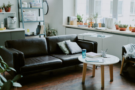 Medium close up of black leather sofa in center of recreation area in on call roomの写真素材