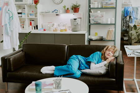 High angle shot of pretty Caucasian nurse sinking into deep dream while lying on conform cotton cushions, she sleeping calmly in on call roomの写真素材