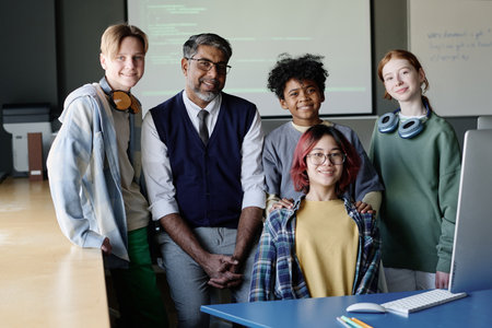 Group portrait of mature biracial teacher of Computer Science and his multi-ethnic teen students...