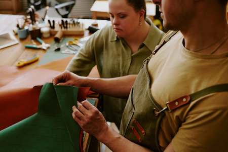 High angle shot of male tailor demonstrating natural fabrics to his female client with down syndrome