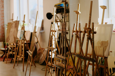 No people shot of set of wooden easels in modern art school interior in daylight, copy spaceの写真素材