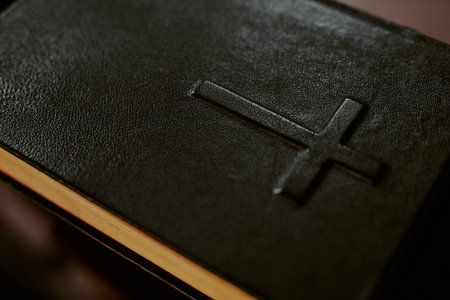 Close up of black leather cover of Holy book, cross in center of Bible