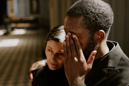 High angle shot of African American man hugging his mother while crying