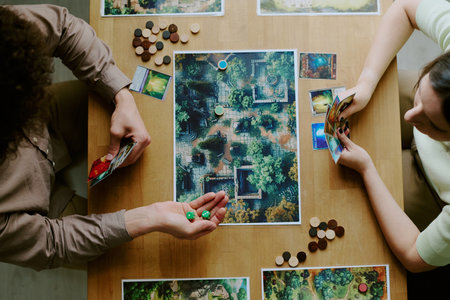 Top-down shot of young man and woman playing modern roll-and-move fantasy board gameの写真素材