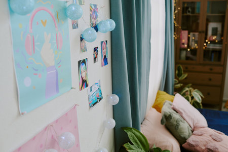 Cozy bedroom with an array of personal photos on wall, illuminated with string lights. Green...
