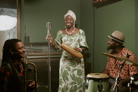 Cheerful male and female Black jazz musicians playing in band smiling while talking about new album during rehearsalの写真素材