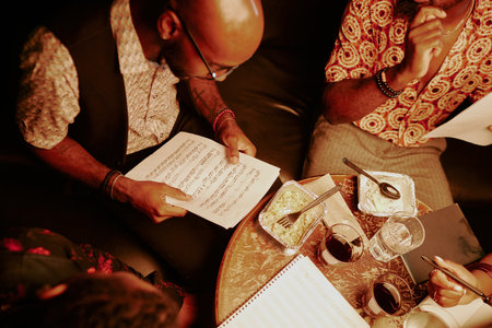 High angle view of jazz band musicians learning song while having dinner in local cafe late in eveningの写真素材