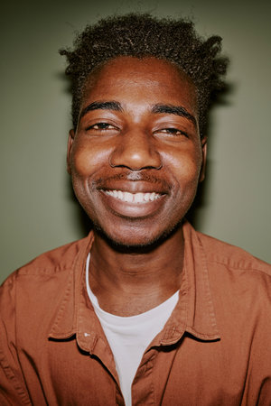 Medium close up portrait of young and handsome black man smiling widely ...
