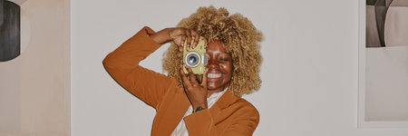 Website banner of young woman holding yellow camera and taking photos
