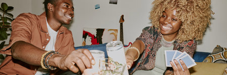 Website banner of biracial friends playing cards and clinking glasses with beverageの写真素材