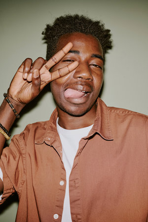 Young black man making faces while posing for photoの写真素材