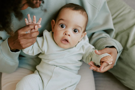 Male infant making surprising face while his mother holding himの写真素材
