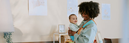 Website header of young African American mother carrying her baby boy in multicolored wrap in light nurseryの写真素材