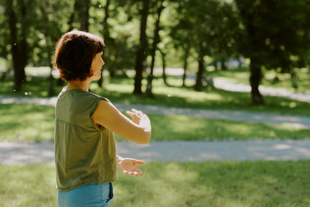 Unrecognizable senior toned woman meditating in park during summer day, she surrounded by precious natureの写真素材