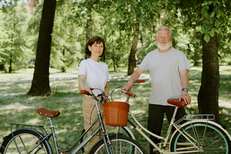 Portrait of senior couple with old fashioned bikes in park, they smiling sincerelyの写真素材