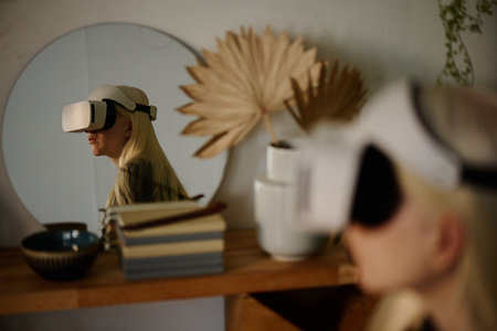 Young Caucasian woman with long white hair wearing VR headset reflected in mirror on shelf
