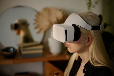Medium closeup of young white-haired woman wearing VR headset using augmented reality app, copy spaceの写真素材