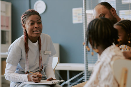 Nurse interacting with family members in medical office environment Engaging in conversation and writing notes, creating a professional and caring atmosphere in healthcareの写真素材