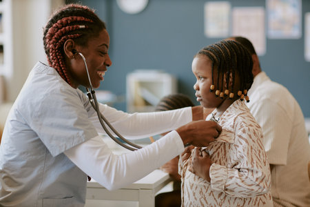 Smiling nurse using stethoscope to examine child in a medical office setting while ensuring comfort during check-upの写真素材
