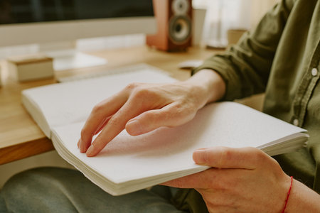 Medium close up of unrecognizable male hand touching dots on page bookの写真素材