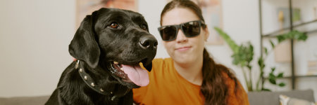 Website header of female owner with disability and her lovely black Labradorの写真素材