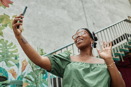 Low angle shot of happy African American woman taking selfie while in eco cafeの写真素材