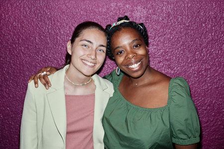 High angle portrait of biracial friends smiling widely and looking at cameraの写真素材