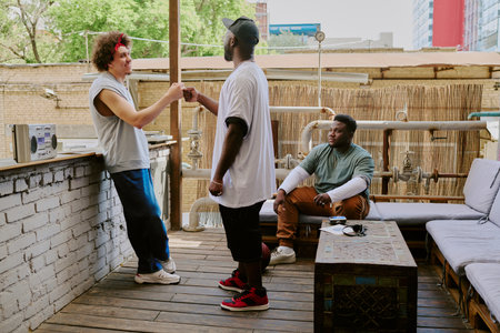 Biracial old friends dressed in street style clothes having meeting in backyard