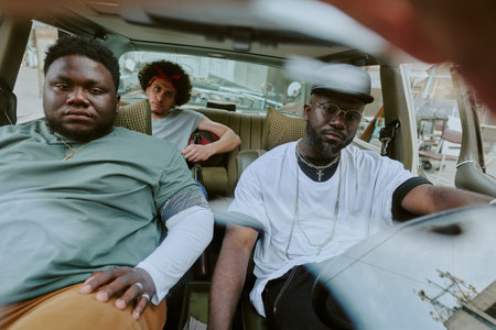 Biracial brutal band sitting in old car, they on road tripの写真素材