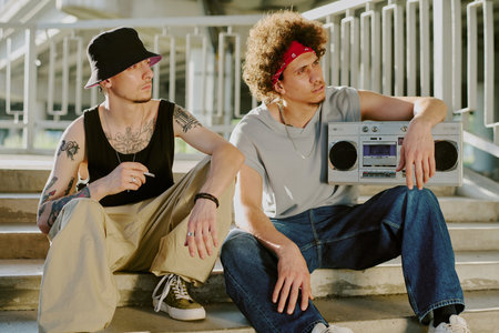 Biracial friends hanging out together and listening to music via retro tape recorderの写真素材