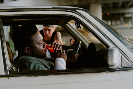 Side view hot of man sitting in car and lighting cigaretteの写真素材