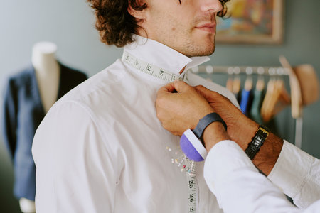 Unrecognizable tailors hands with buff bracelet for needles taking neck measurementsの写真素材