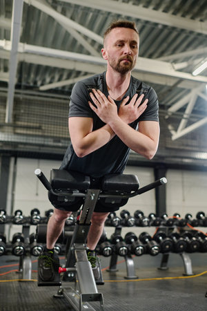 Low angle shot of male athlete doing hyperextension to gain back muscles