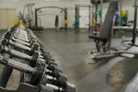 Medium close up of metal rack with metal dumbbells in empty workout zoneの写真素材