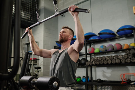 Professional Caucasian athlete using weight machine to bulk muscle