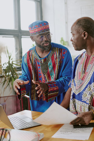 Vertical shot photo of man gesticulating while explaining new project to his colleagueの写真素材