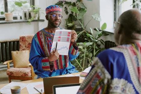 African American subordinate demonstrating annual report to his boss in officeの写真素材