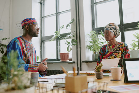 Low angle shot of African American startuper telling about new project to his partners in cozy officeの写真素材