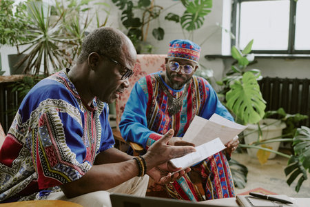 African American colleagues comparing data of last report while having break in eco zone of officeの写真素材