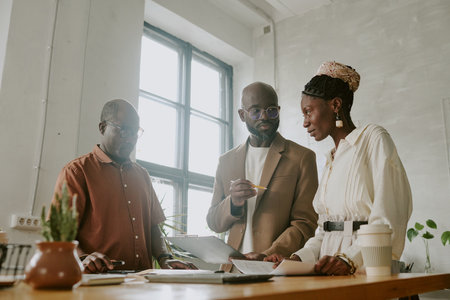 Low angle shot of African American team making new project together in officeの写真素材