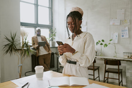 African American office worker surfing in internet while her colleague reading article in tabletの写真素材