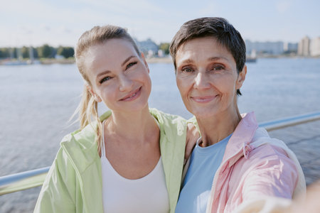 Selfie of young adult and senior Caucasian mom, they hugging each other and smiling
