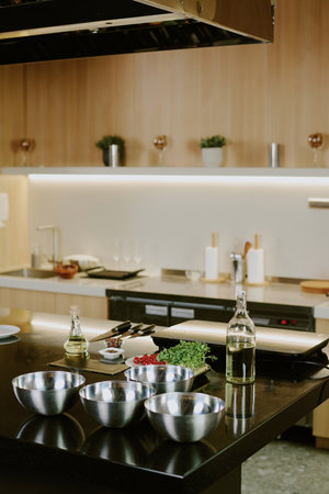 Vertical shot of modern kitchen counter with crockery and electronic devices on black topの写真素材