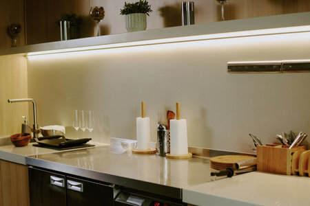 Wooden kitchen counter with kitchenware and dishes on white granite topの写真素材