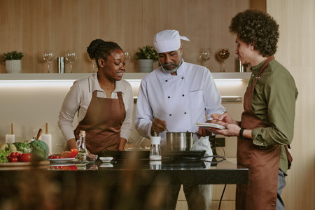 Indian chef stirring special sauce while his intern watching him and his actions attentivelyの写真素材