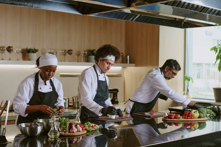 Multiracial cooking team working together in restaurant kitchen, they preparing ingredientsの写真素材