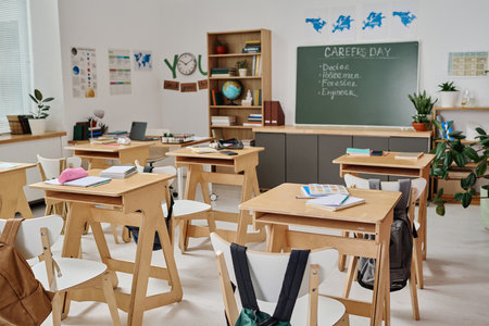 No people wide shot of modern school classroom interior equipped with wooden furniture and decorated with posters on career guidance dayの写真素材