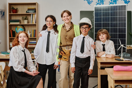 Group of gen alpha students and female engineer posing for portrait in classroom on vocational guidance day at schoolの写真素材